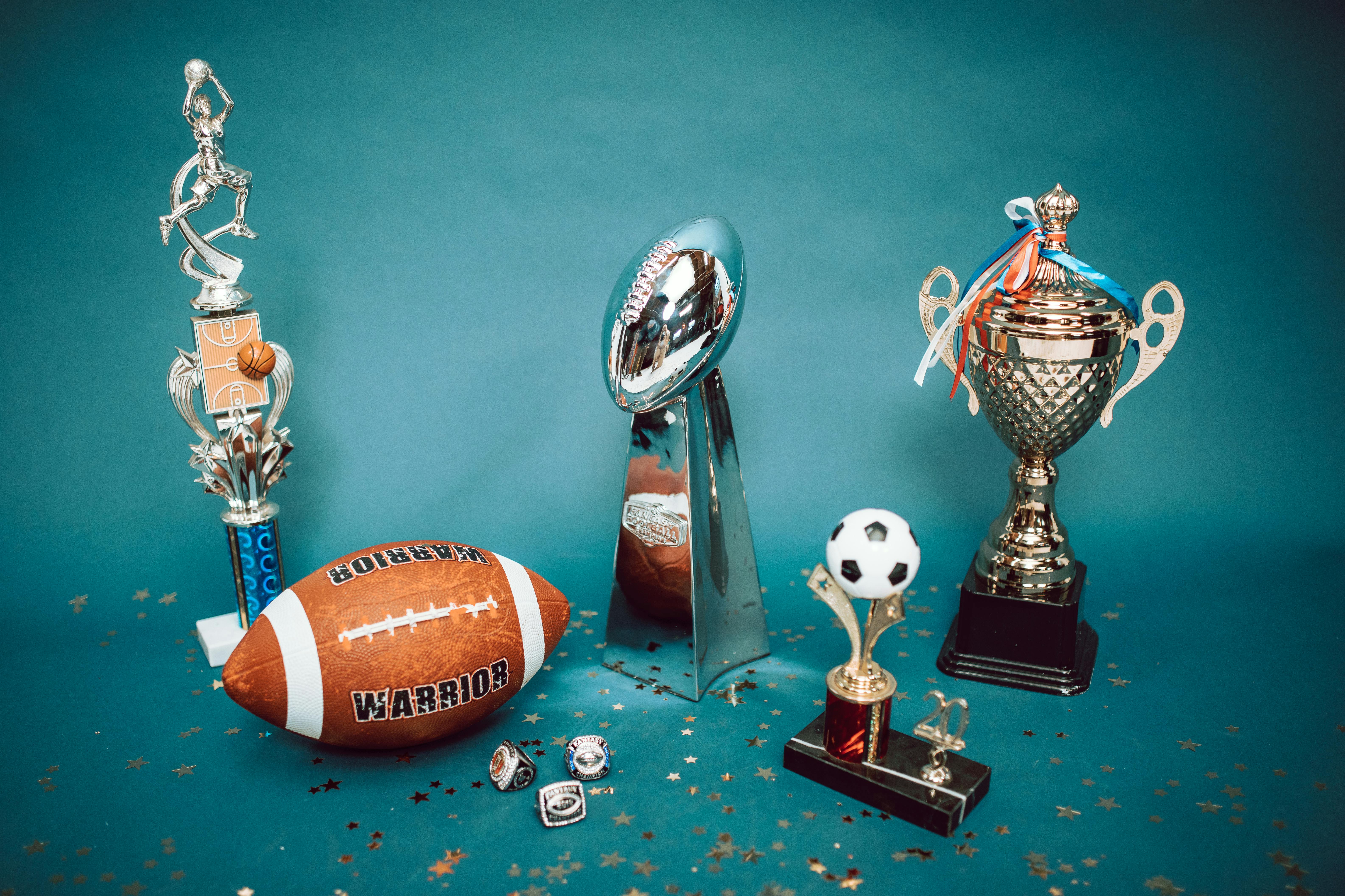 trophies-and-football-in-front-of-photo-backdrop