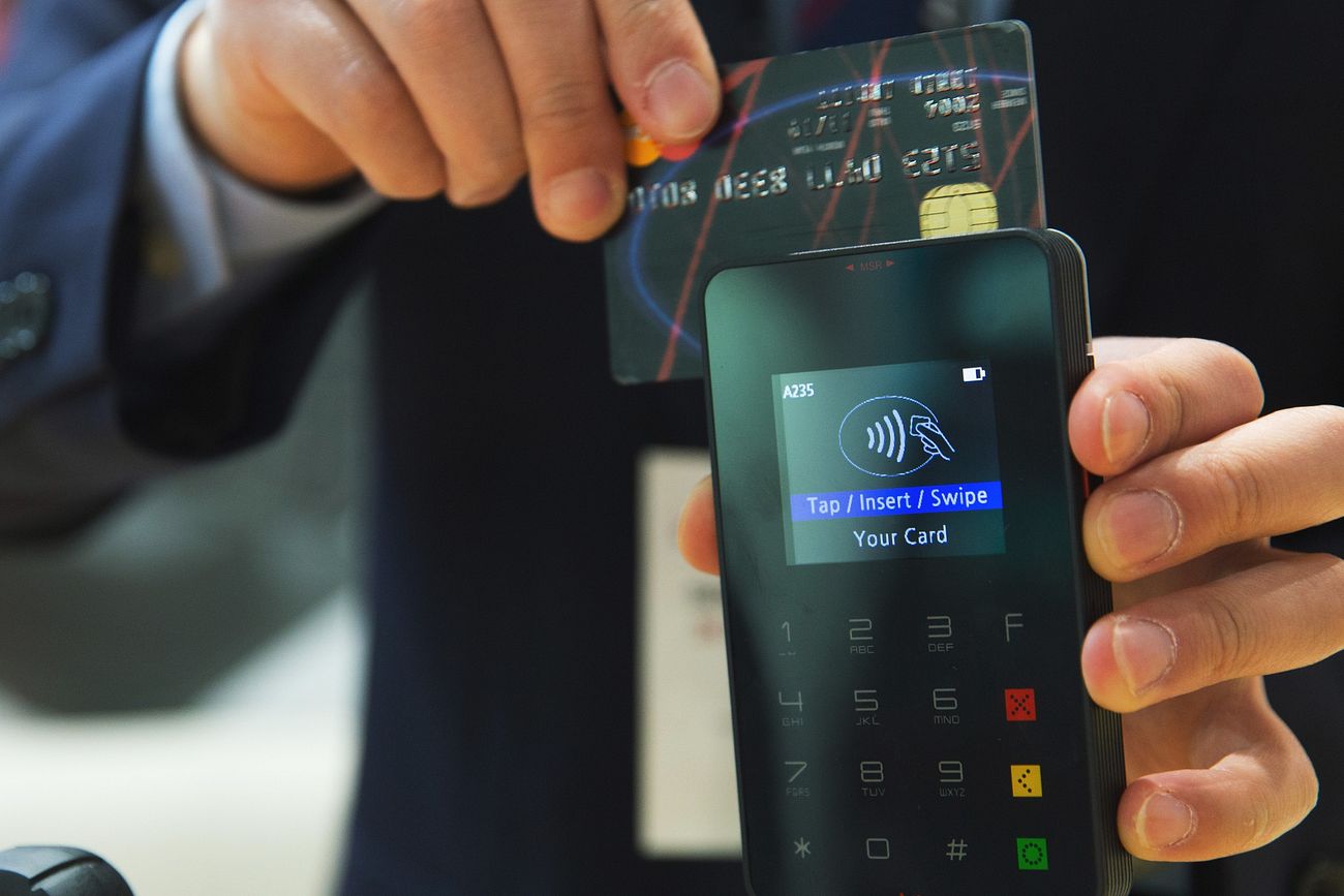 man-holding-credit-card-to-phone