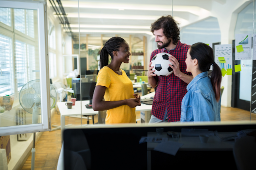 coworkers-discussing-sports-while-holding-soccer-ball