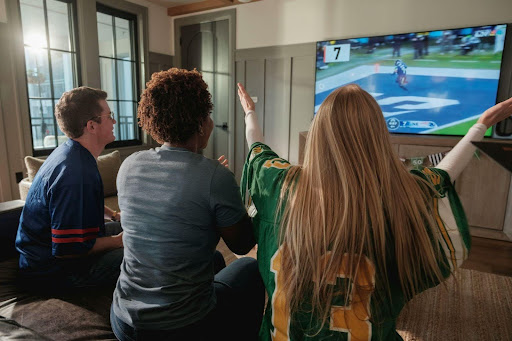 three-people-watching-football-game-on-tv-cheering