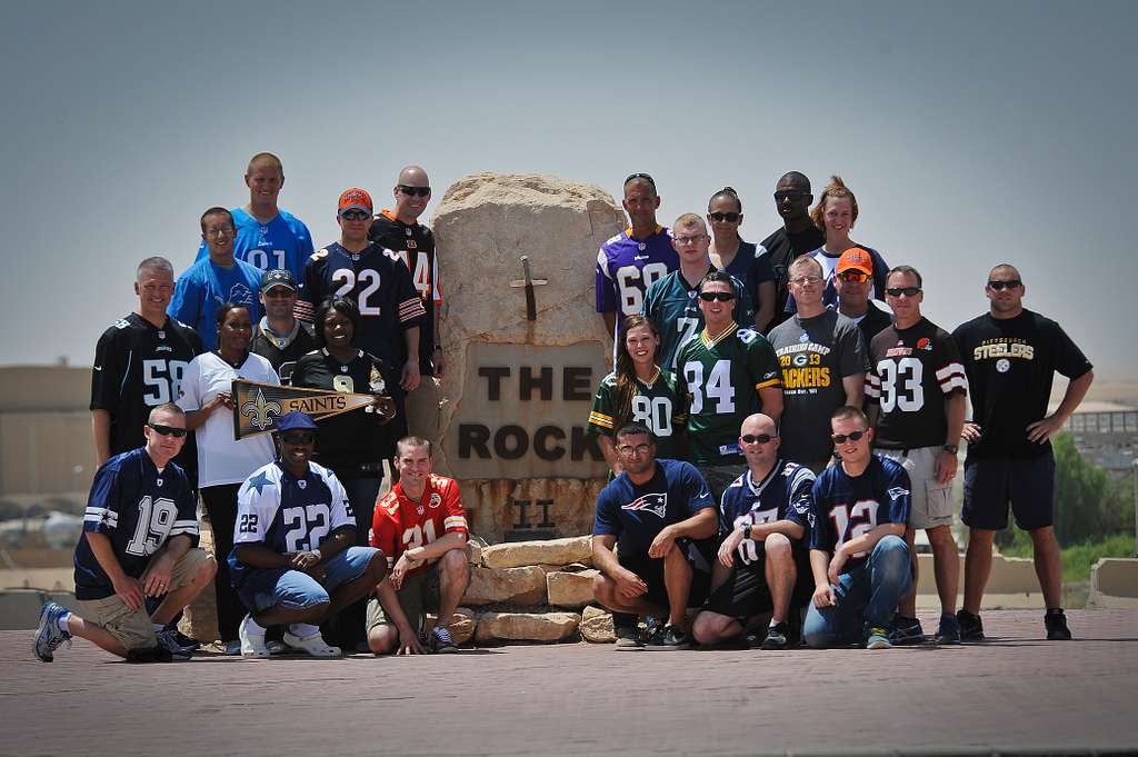 group-of-nfl-fans-with-jerseys-posing-for-picture-by-rock